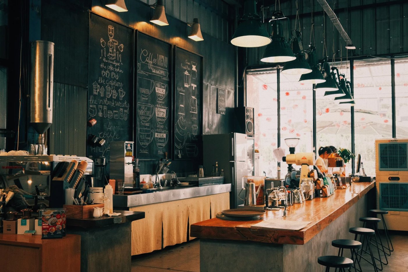 Café-Theke mit Kreidetafel, Espressomaschine und Barista