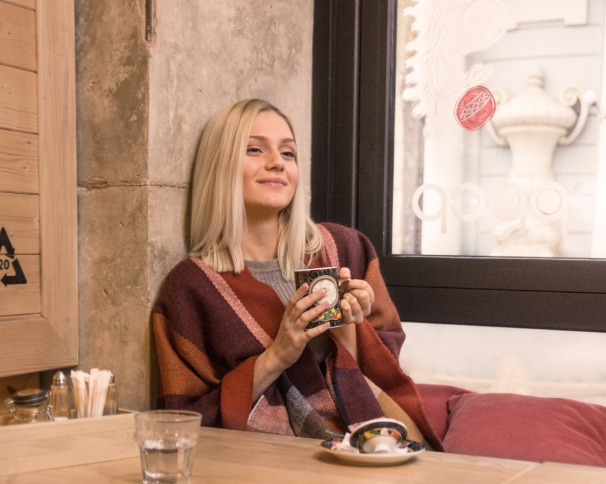 Frau mit Teetasse am Fenster